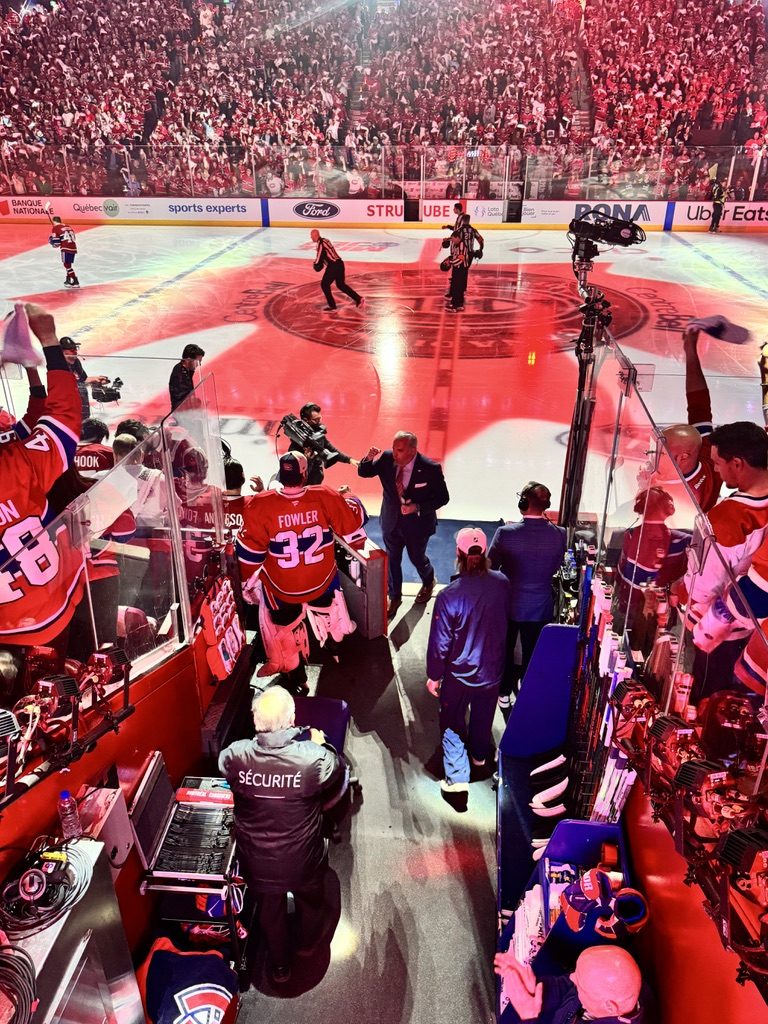 Walking back off the ice past the Canadiens bench, high-fiving a player, among camera crews, technicians and a security guard, the crowd in red beyond the glass.