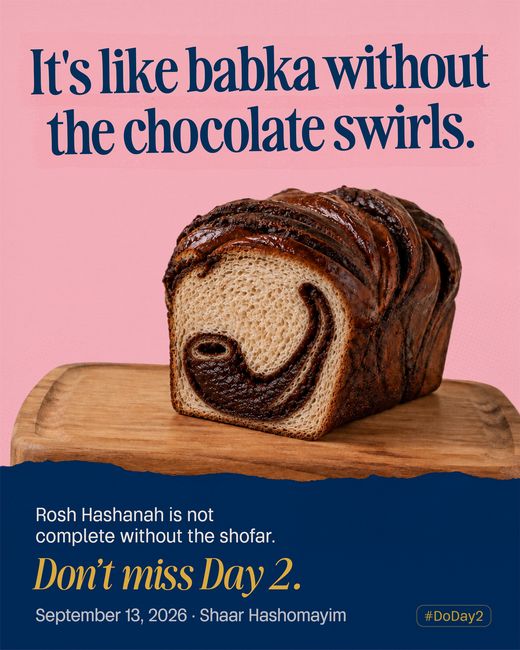 A cut loaf of babka on a board, the chocolate swirl inside curling into the shape of a shofar.