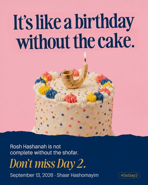 A sprinkled birthday cake on pink, its lit candle rising from a small ram’s horn set into the icing.