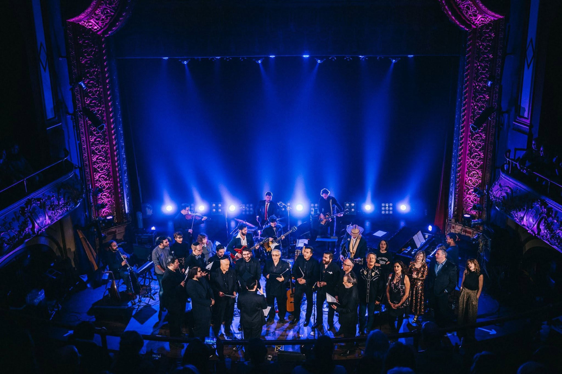 From the balcony of the Rialto Theatre: the full company assembled on a blue-lit stage &mdash; choir, band and guest singers &mdash; before the theatre&rsquo;s ornate gilded proscenium.
